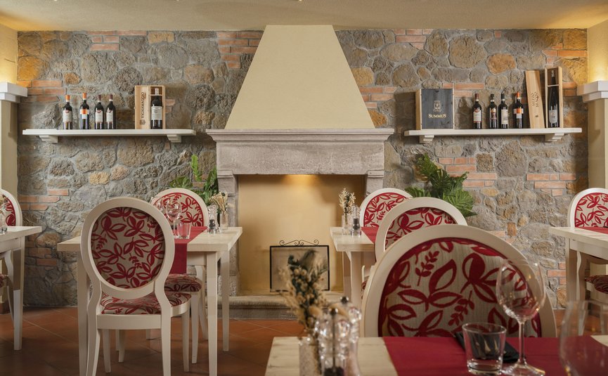 Hotel & Restaurant Casolare Le Terre Rosse ***S © Hotel Casolare Le Terre Rosse Gemütliches Restaurant mit Steinkamin und dekorativen Weinflaschenregalen