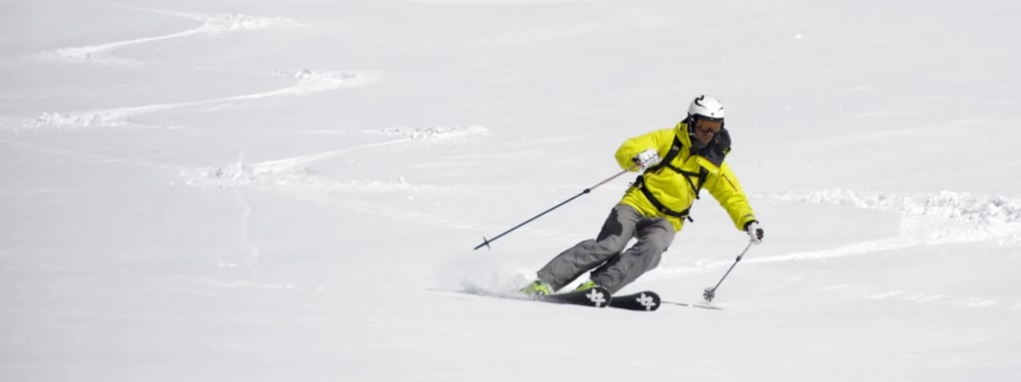Dolomiti Spring Days Sciatore con giacca gialla che scia sulla neve fresca