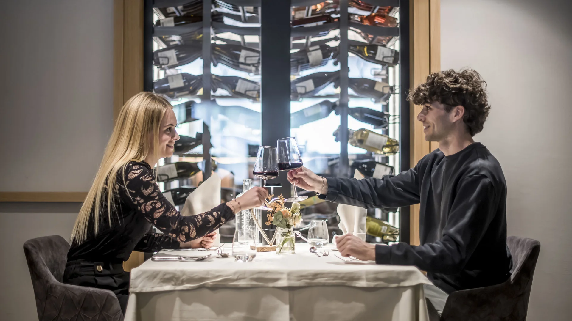 Paar stößt mit Rotwein in einem modernen Restaurant an