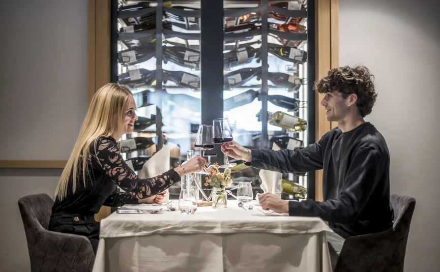 Paar stößt mit Rotwein in einem modernen Restaurant an