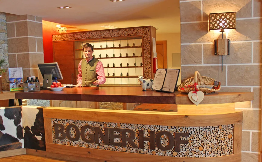 Rezeption mit Empfangstresen und Angestelltem im Bognerhof