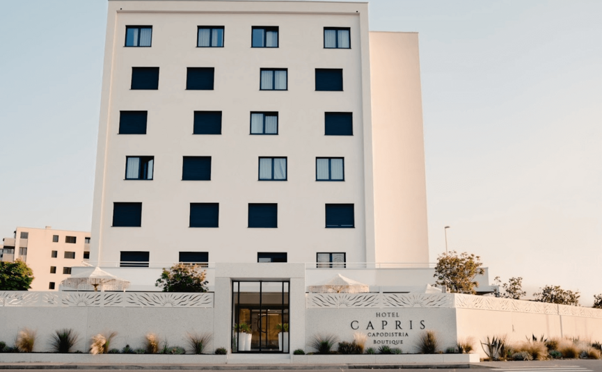 Hotel Capris **** © Hotel Capris Capodistria Boutique Modern wit hotelgebouw met zwarte luiken en naam op de gevel