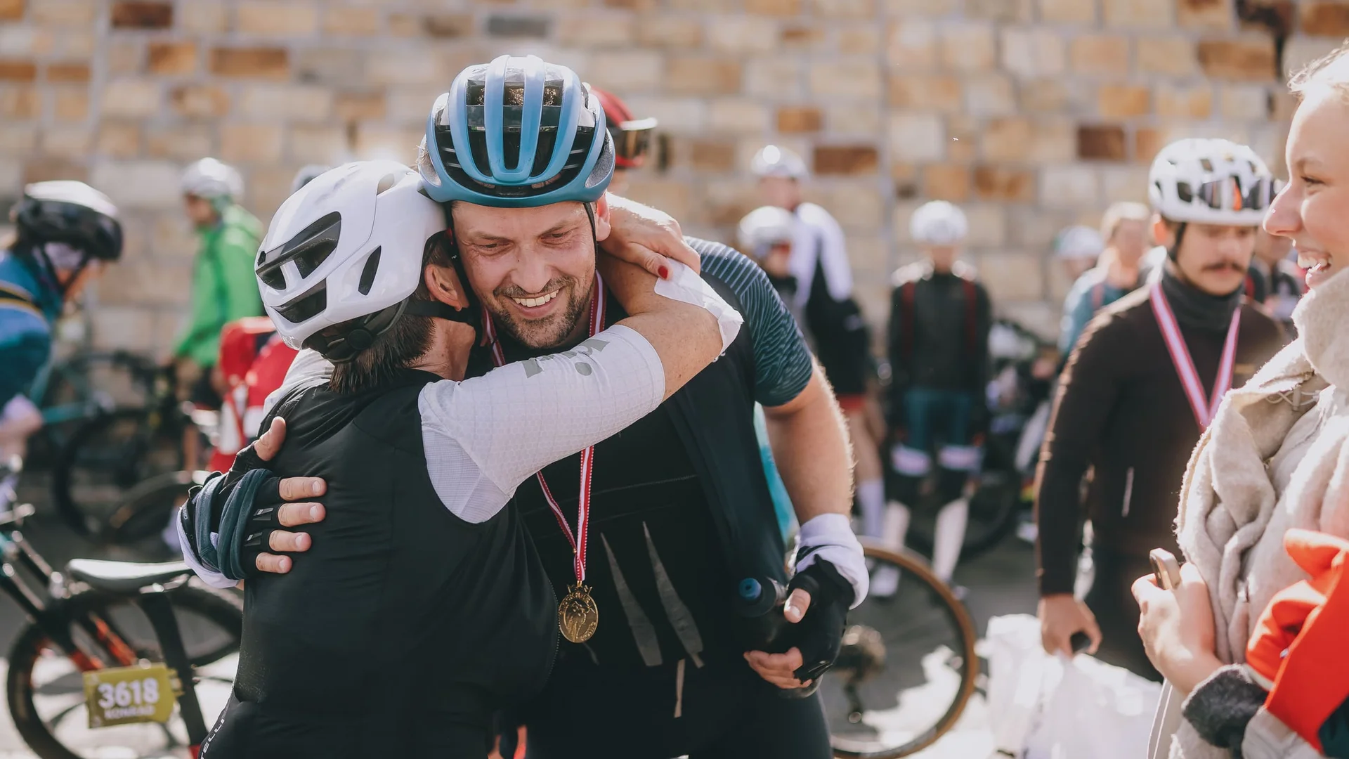 Glocknerkönig 2026 © BRUCK FUSCH GROSSGLOCKNER JFK Photography Zwei Radfahrer umarmen sich nach einem Rennen, einer trägt eine Medaille