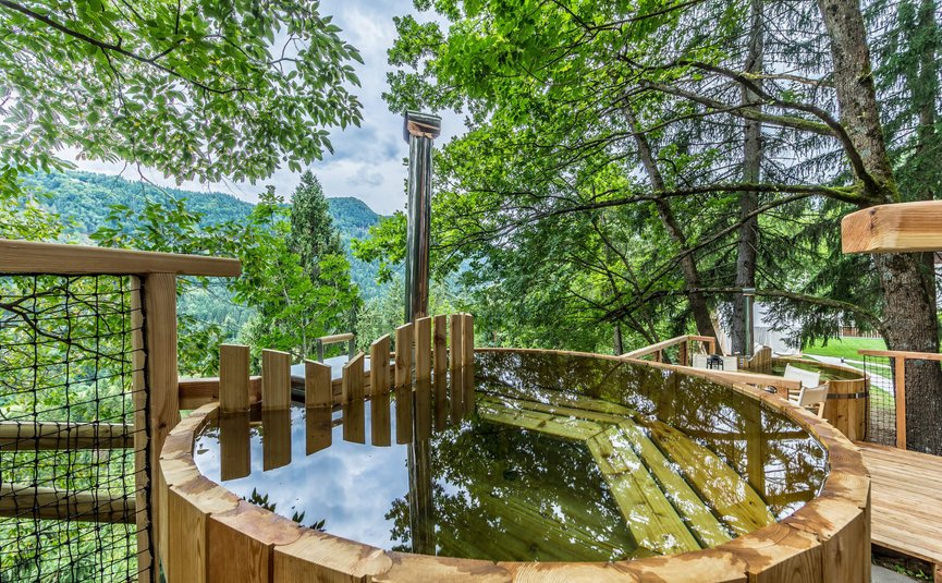 Vasca di legno piena d'acqua su una terrazza nella foresta