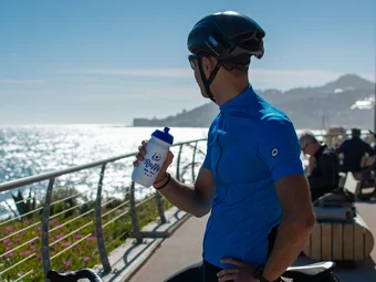 Ligurian Riviera © Valentina Morri Italy Cyclist resting by the sea holding a water bottle