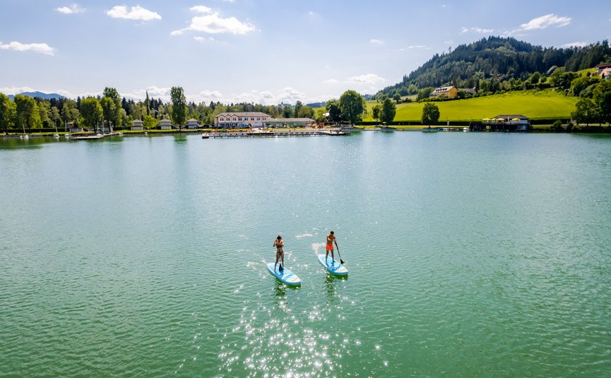 Bed&Breakfast Mittelkärnten © Michael Stabentheiner - Region Mittelkärnten Two people paddleboarding on a calm lake on a sunny day