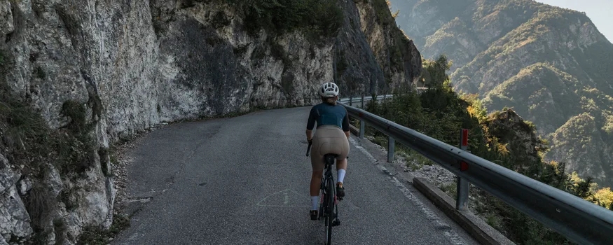 Cristallo Sport & Wellness Hotel **** © marc.moves x velysiped Radfahrer auf Bergstraße entlang Felswand mit Gebirgsblick