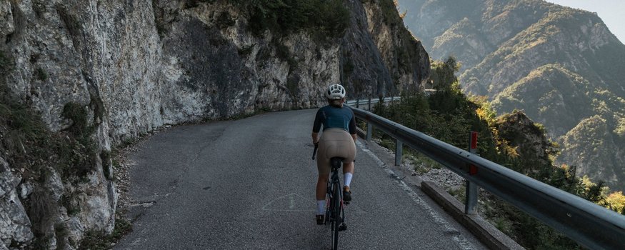 Cristallo Sport & Wellness Hotel **** © marc.moves x velysiped Radfahrer auf Bergstraße entlang Felswand mit Gebirgsblick