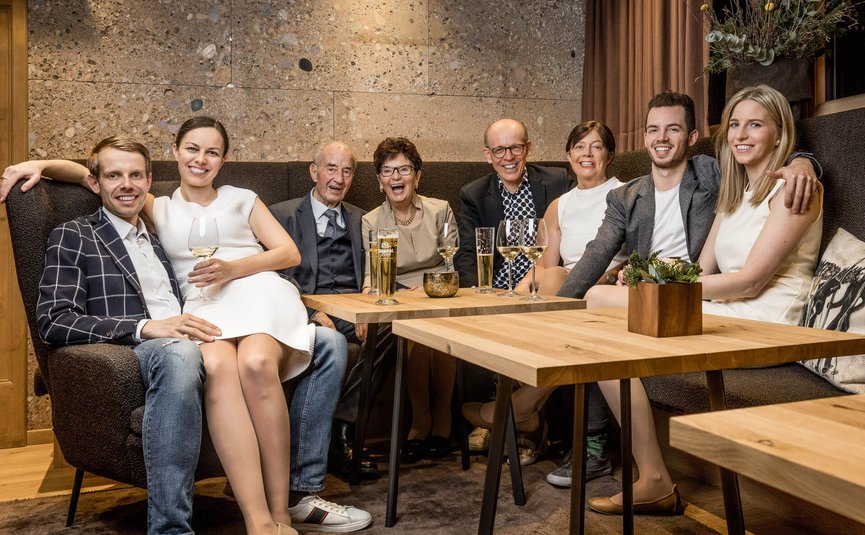Happy family sitting together on a sofa with drinks in a cozy living room