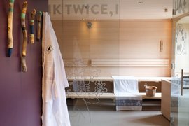Modern sauna with wooden benches, towel, and sauna bucket