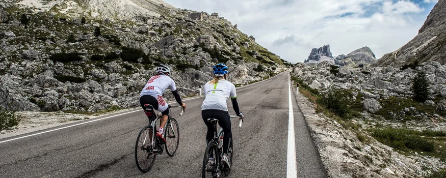 Hotel Gran Paradiso **** © Paola Finali Zwei Radfahrer fahren eine Bergstraße mit Felsen und wolkigem Himmel.