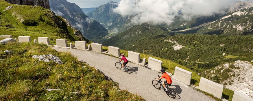 Hotel Boka *** © Ziga Koren - Archive Soca-Valley.com Zwei Radfahrer auf Bergstraße mit Blick auf Berge und Wolken