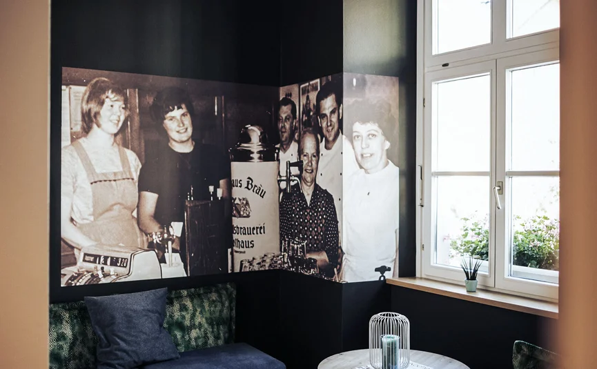 Posthorn Hotel-Ristorante Accogliente salottino con pareti scure, murale fotografico, divani e tavolino vicino alla finestra