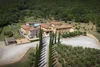 Collectief onderzoek © Hotel Casolare Le Terre Rosse Luchtfoto van een landhuis met zwembad omgeven door bomen en olijfgaard