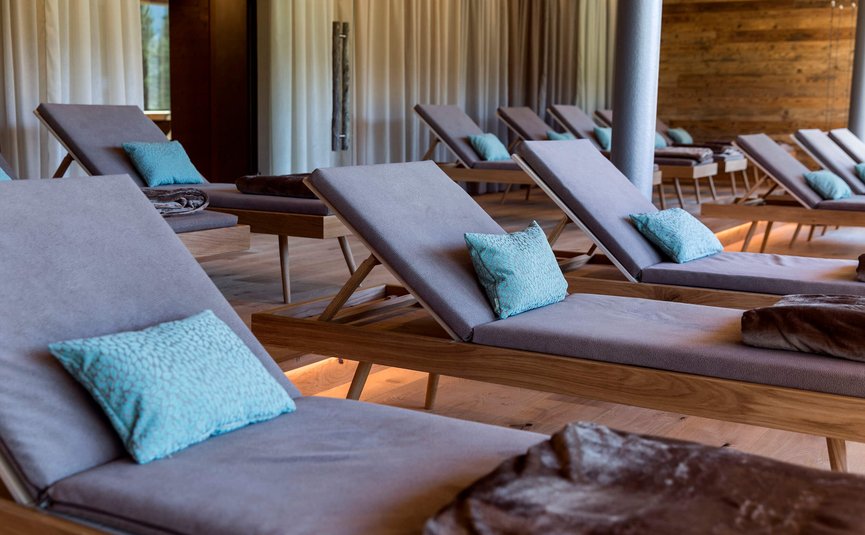 Leere Liegestühle mit blauen Kissen in einem ruhigen Wellnessraum