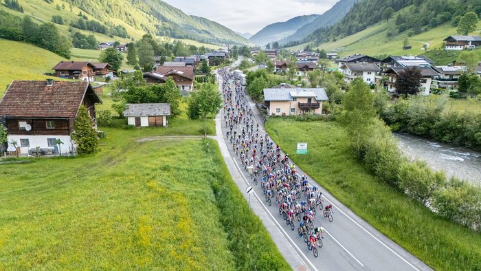 29. Glocknerkönig am 7. Juni 2026 © Posch Photography Tourismusverband BRUCK FUSCH GROSSGLOCKNER Fahrradrennen durch ein malerisches Tal mit Häusern und Fluss
