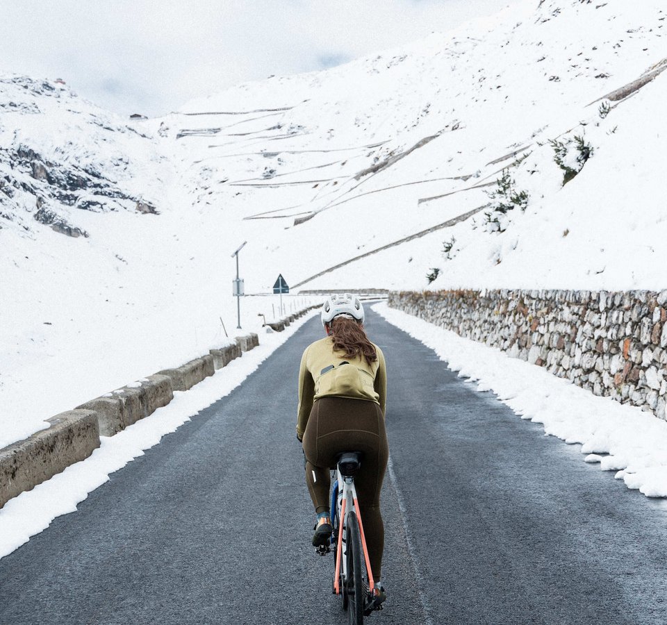 Rennrad-Saisonausklang in Südtirol © Marc Mähler Radfahrerin auf bergiger Straße mit Schnee an den Seiten