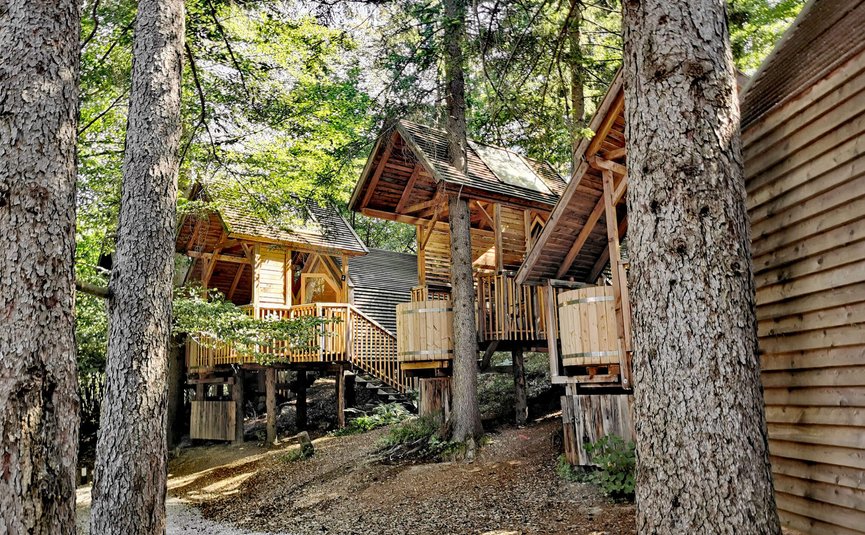 Bungalow di legno su pali in una foresta ombreggiata