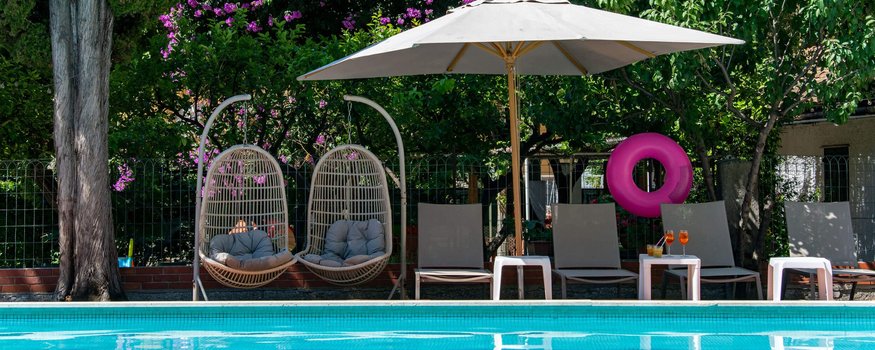 Rennradfrühling an der Ligurischen Riviera © Paolo Penni Martelli Pool mit zwei Hängesesseln und Liegestühlen unter Sonnenschirm