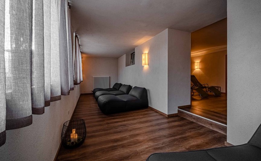 Sala relax con lettini neri e luce soffusa