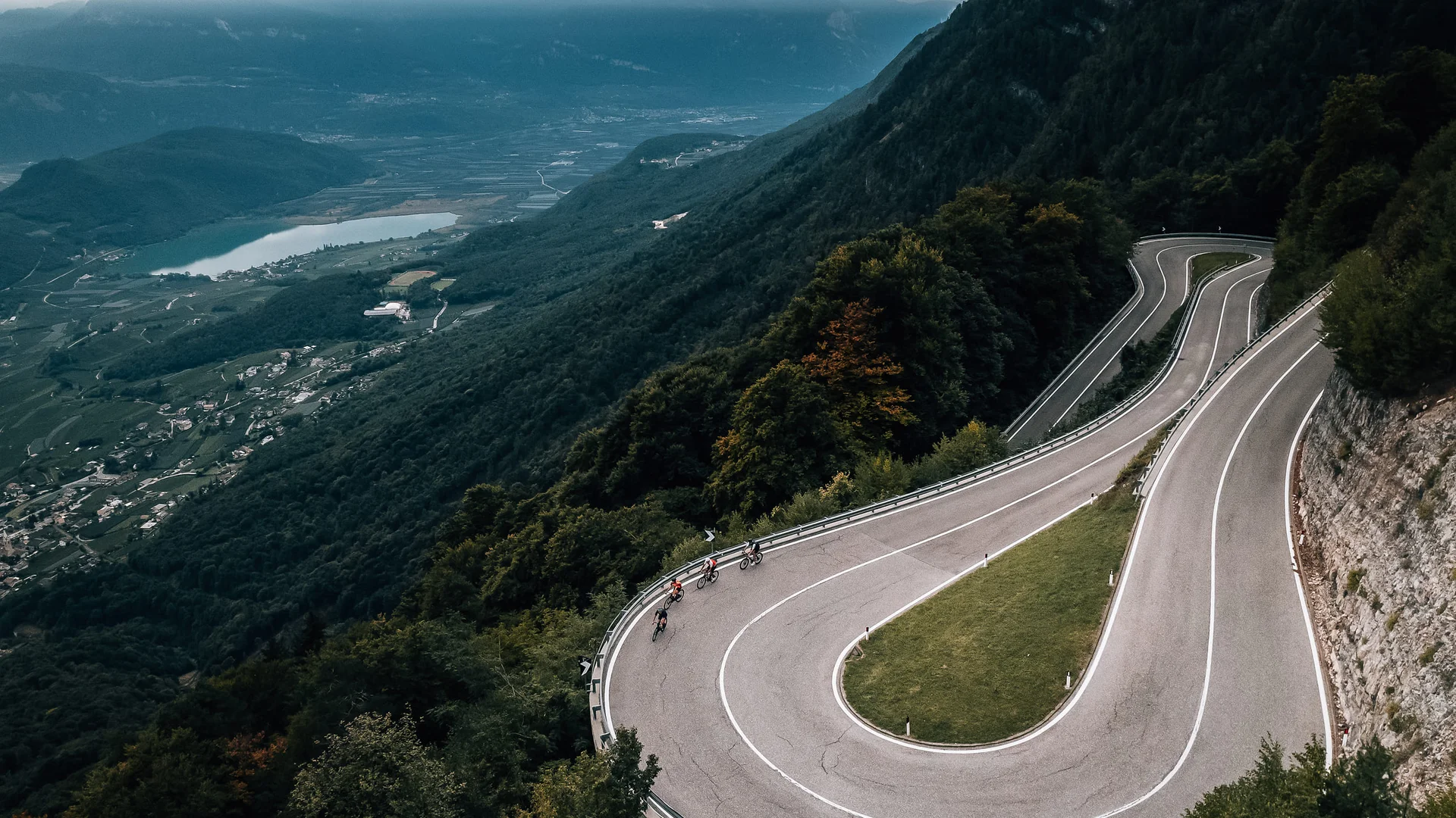 3 Regionen für den Rennradurlaub im Herbst © Jens Scheibe Radfahrer fahren eine enge Serpentinen-Straße durch bewaldete Berge