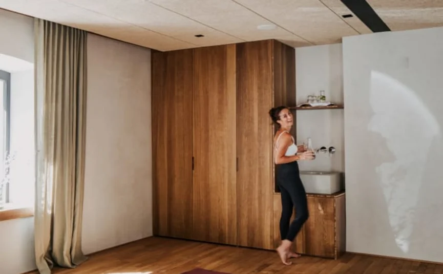 The Mountains are calling Package Woman in yoga room with prepared mats and towels