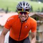 Fahrradfahrer mit Helm und Sonnenbrille in orangefarbenem Trikot