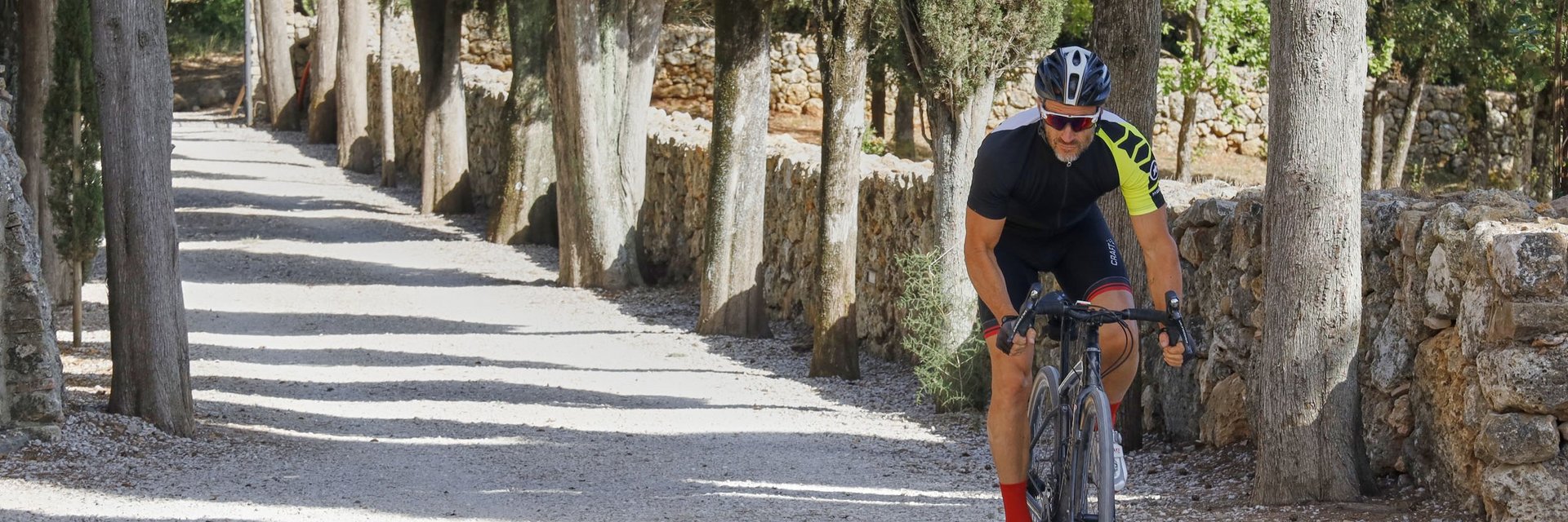 Hotel & Restaurant Casolare Le Terre Rosse ***S © Asha Balogh Radfahrer fährt auf einem von Zypressen gesäumten Kiesweg