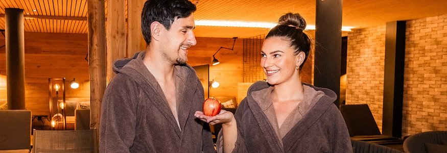 Landrefugium Obermüller ****S © Stefan J. Wolf Photography Paar in Bademänteln im Spa, Frau hält einen Apfel
