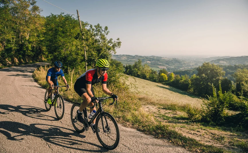 Vacanze in bici da corsa sulla costa adriatica © Alex Moling Due ciclisti pedalano su una strada di campagna in una zona collinare.