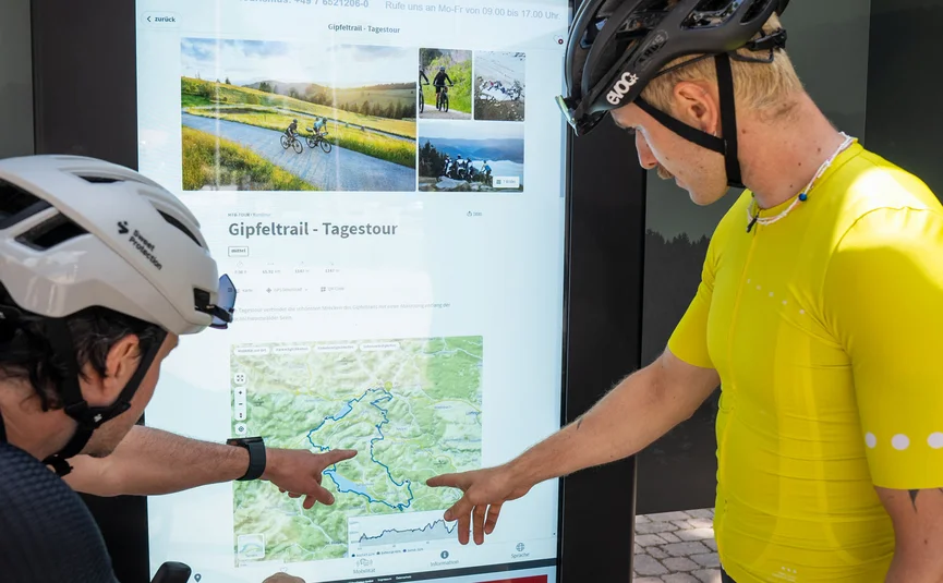 Rennrad Urlaub im Schwarzwald © Baschi Bender Zwei Radfahrer sehen sich eine digitale Karte am Informationsdisplay an