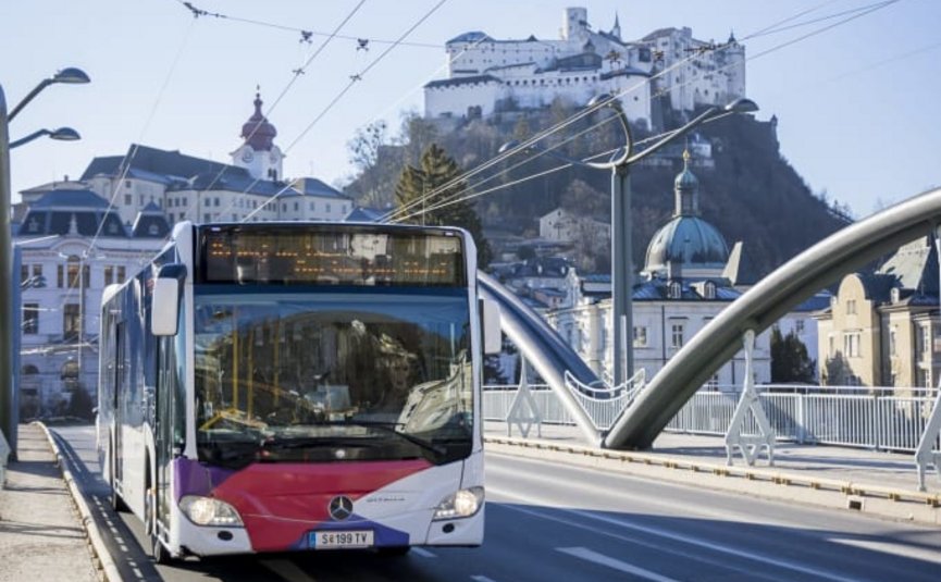 Stadtbus auf einer Brücke mit Schloss auf einem Hügel im Hintergrund