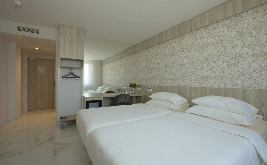 Hotel Capris **** © Hotel Capris Capodistria Boutique Moderne hotelkamer met twee bedden en bloemrijke wanddecoratie