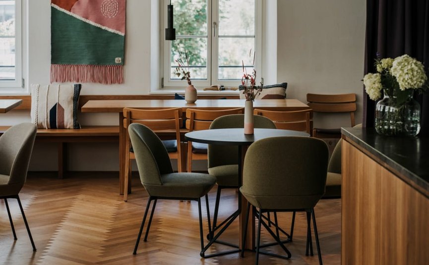 Gezellige moderne eetruimte met ronde tafels en groene stoelen