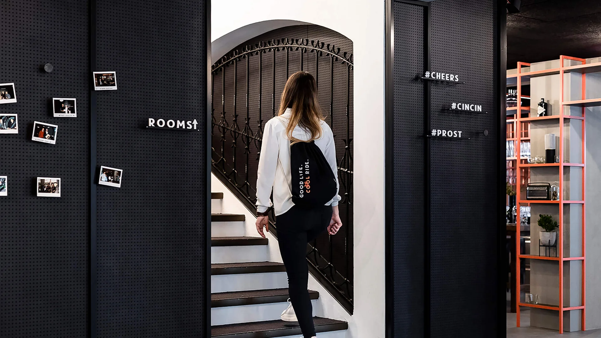 Woman with backpack walking up stairs in modern indoor space