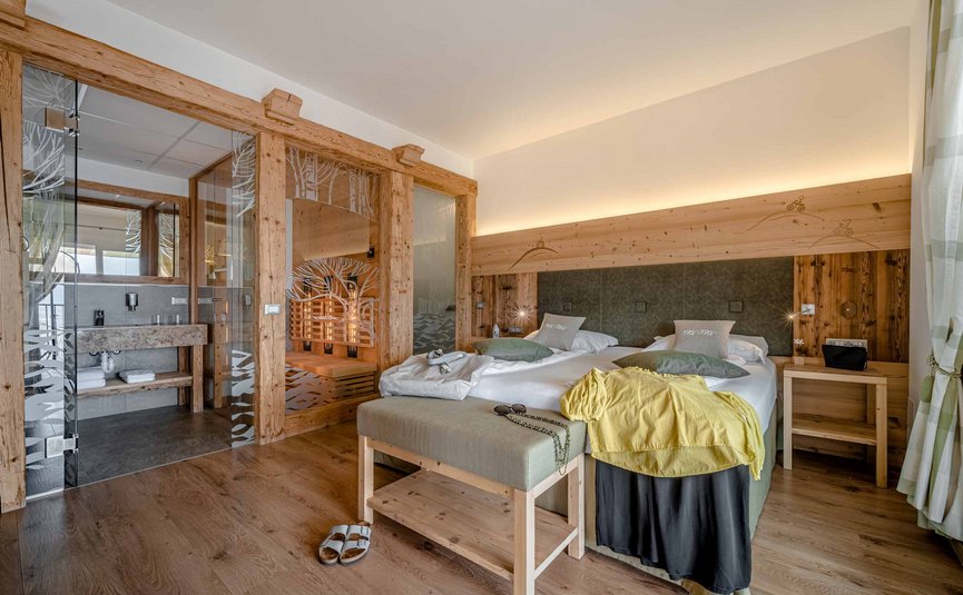 Camera d'hotel accogliente con sauna e arredamento in legno