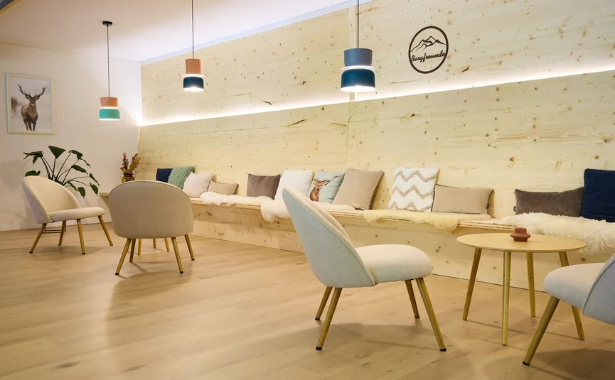 Gezellige wachtruimte met houten wanden, stoelen en kleurrijke kussens