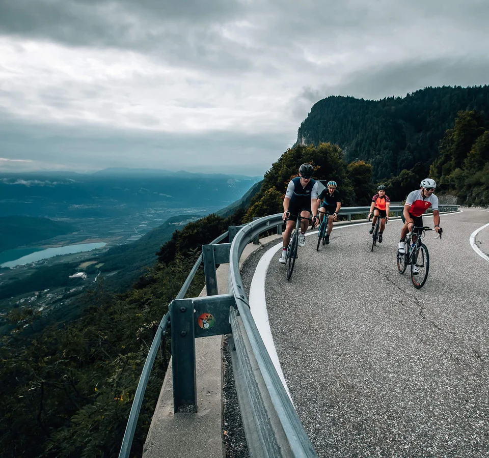 Roadbiken im Südtiroler Unterland © Jens Scheibe Fahrradfahrer fahren auf einer kurvigen Bergstraße mit Talblick