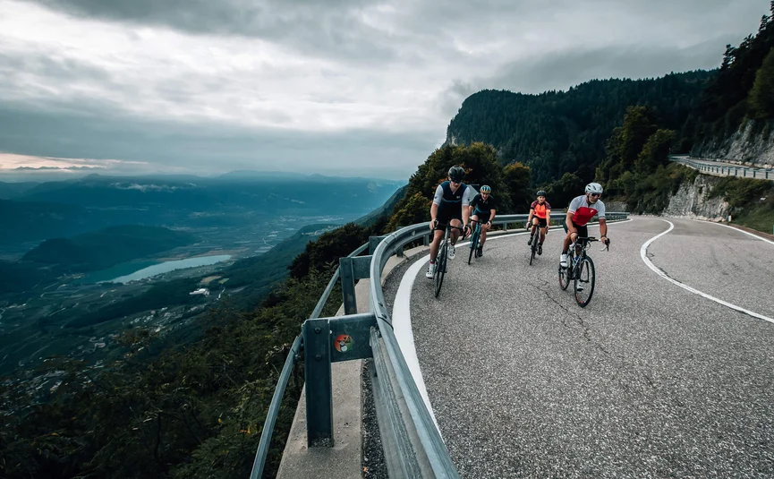 Mendelpass © Jens Scheibe Fahrradfahrer fahren auf einer kurvigen Bergstraße mit Talblick
