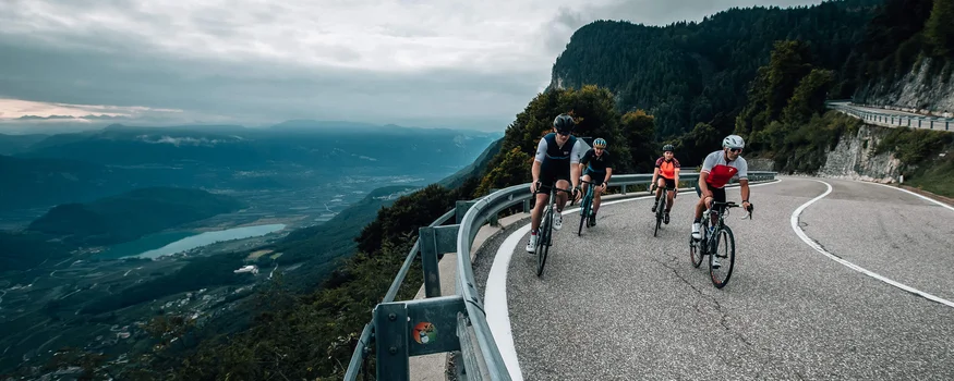 Herbst-Rennrad-Wochenende in Tramin © Jens Scheibe Fahrradfahrer fahren auf einer kurvigen Bergstraße mit Talblick