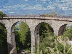 Il sud dell'Alto Adige © Thomas Monsorno - TV Castelfeder Ciclisti su un ponte ad archi di pietra in una zona verde