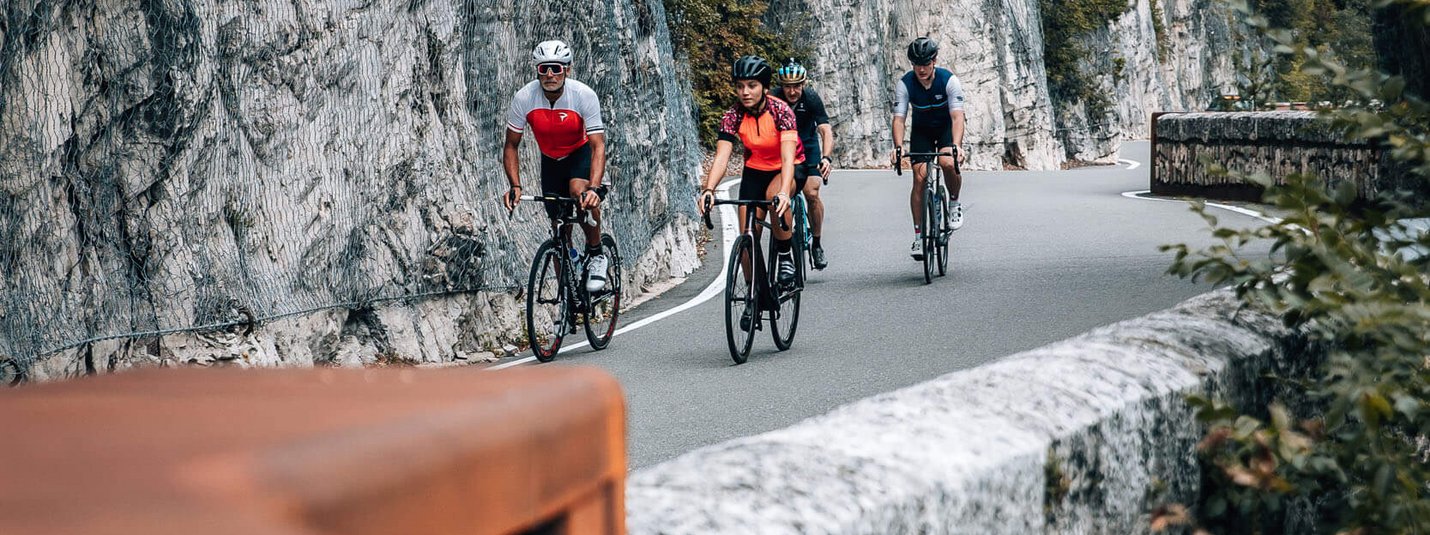 Klassische Mendelrunde © Jens Scheibe Vier Radfahrer fahren auf bergiger Straße entlang einer Felswand