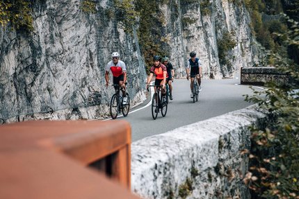 Klassische Mendelrunde © Jens Scheibe Vier Radfahrer fahren auf bergiger Straße entlang einer Felswand