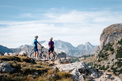 Twee fietsers staan met hun fietsen op een bergpad bij helder weer