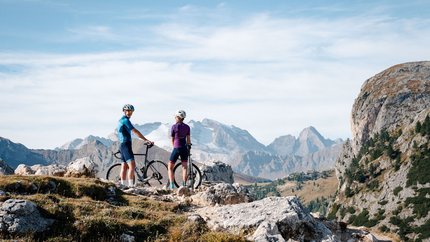 Zwei Radfahrer stehen mit ihren Fahrrädern in den Bergen bei klarem Wetter