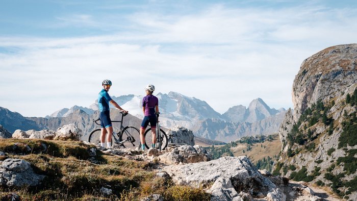 Zwei Radfahrer stehen mit ihren Fahrrädern in den Bergen bei klarem Wetter