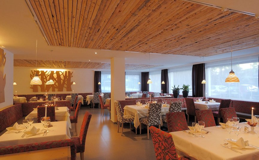 Accogliente ristorante con tavoli apparecchiati e soffitto in legno