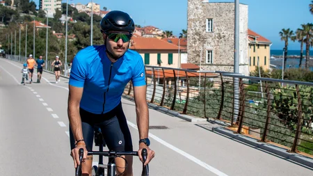 Rennradfrühling an der Ligurischen Riviera © Valentina Morri Italy Radfahrer in blauer Kleidung fährt auf Straße bei sonnigem Wetter