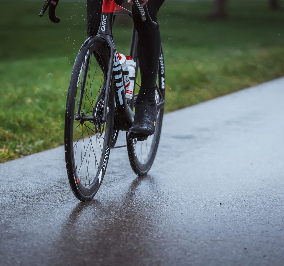 Schwalbe One 365 © Ralf Bohle GmbH Nahaufnahme eines Radfahrers auf einem Rennrad auf nasser Straße