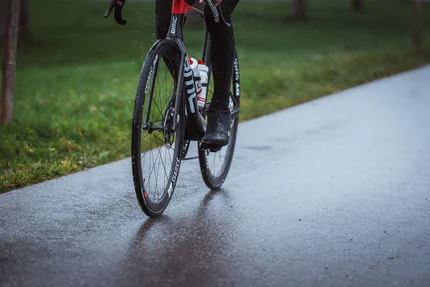 Schwalbe One 365 © Ralf Bohle GmbH Nahaufnahme eines Radfahrers auf einem Rennrad auf nasser Straße